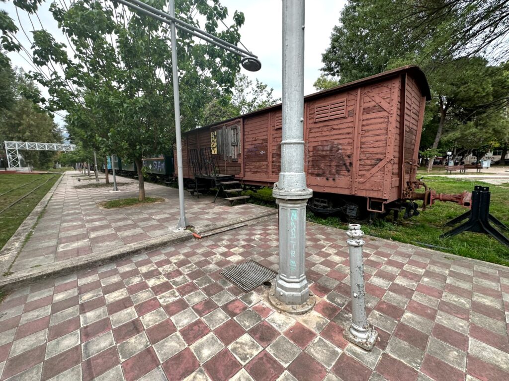 View of Kalamata Municipal Railway station with its classic architecture, featuring train platforms, tracks, and surrounding greenery, offering a glimpse into the region's transportation heritage.