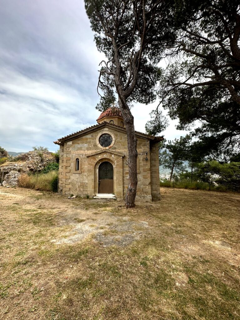 Historic Kalamata Castle in Greece, perched on a hill overlooking the city and the Messinian Gulf, surrounded by lush greenery and offering panoramic views of the Peloponnese region.