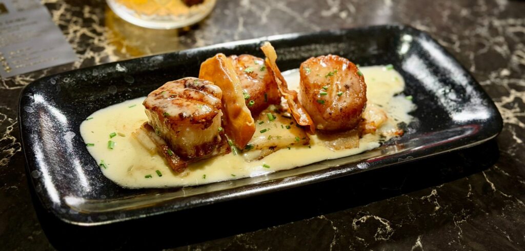 Seared scallops with crispy prosciutto and beurre blanc at The Prime Rib inside Live! Casino & Hotel Louisiana